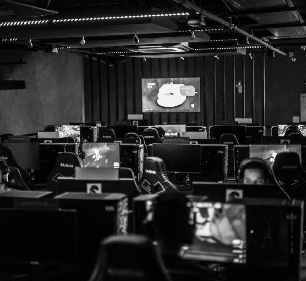 Black and white view of an active esports gaming studio with players immersed in video games.