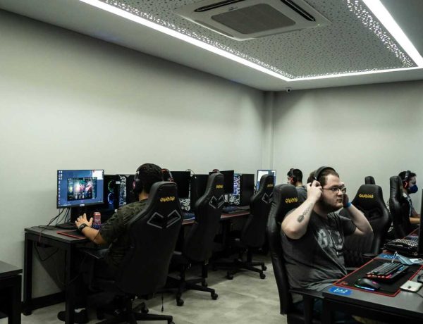 Group of gamers intensely playing video games in a modern esports center.