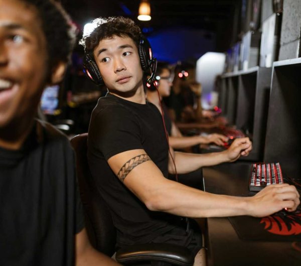 Young gamers engaged in a multiplayer session at an eSports arena with high-end gaming setups.