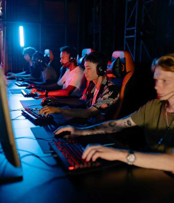 A group of young adults engaged in competitive gaming at a cybercafe.